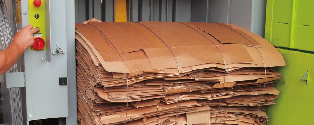 Baled cardboard inside waste baler